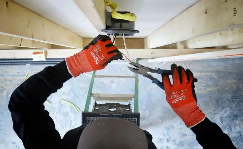 A red-seal electrician installing a new electrical circuit and wiring.