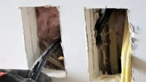 A licensed electrician replacing dangerous aluminum wiring inside a house.