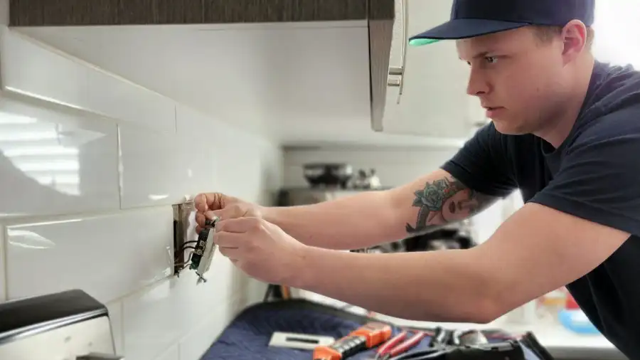 A licensed electrician making electrical repairs on a home in Kelowna BC.
